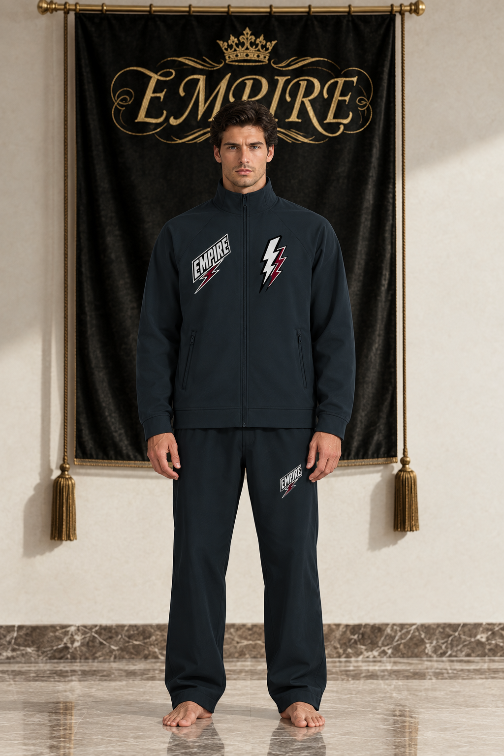 Dark men's EMPIRE stand-collar raglan track jacket with white and burgundy lightning chest graphics, front view on barefoot male model