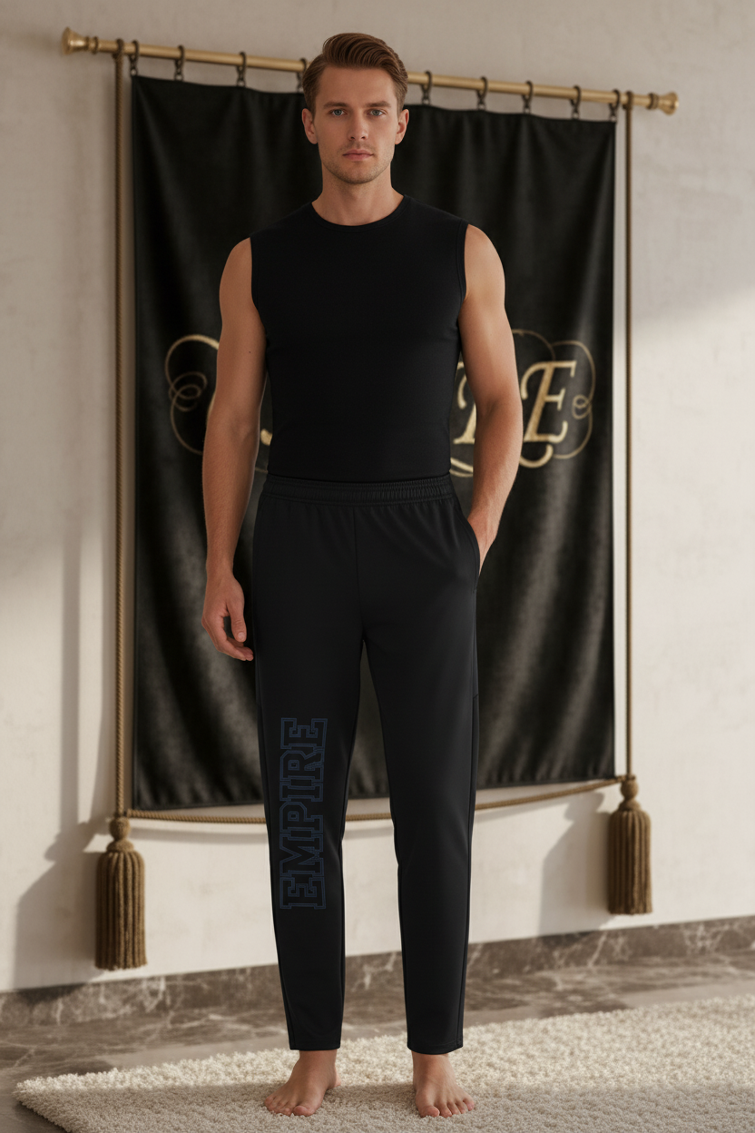 Homme portant le pantalon EMPIRE Travel Pants noir fuselé avec marquage vertical EMPIRE bleu-gris sur la jambe, vue de face.