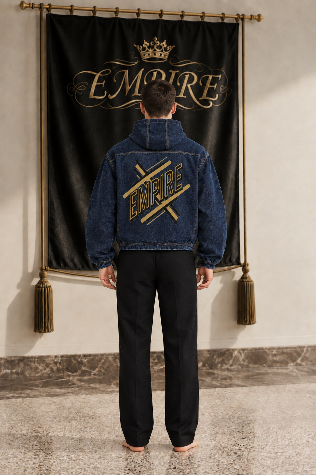 EMPIRE men's dark indigo hooded denim jacket with large black and gold EMPIRE graphic, back view on barefoot male model