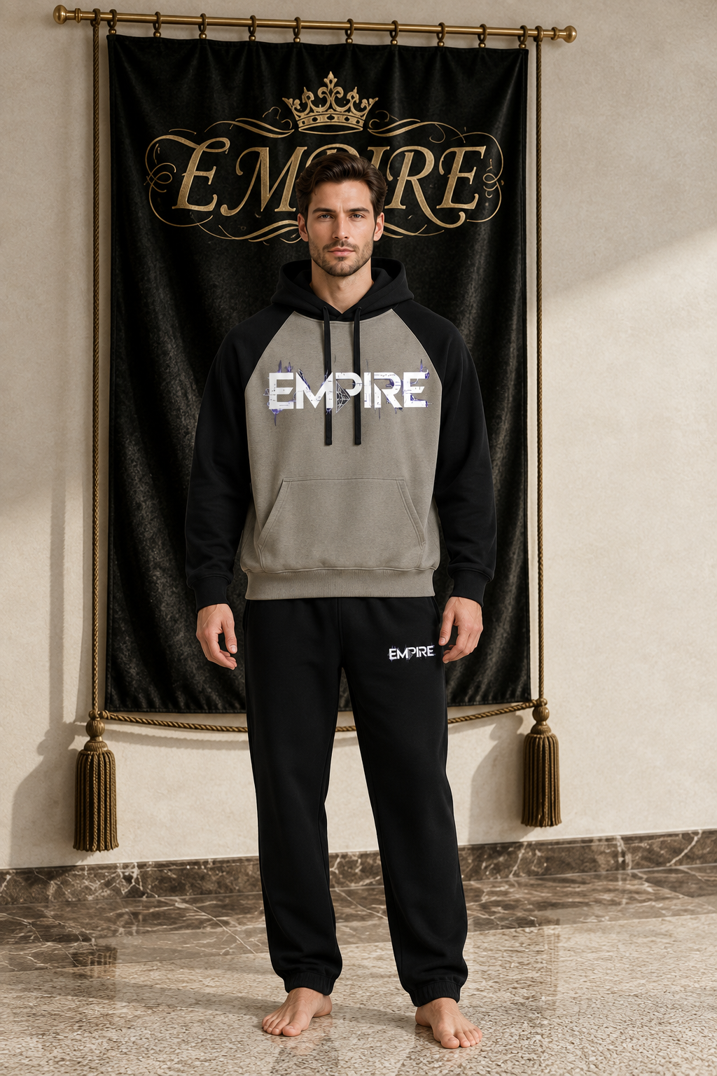 Taupe and black men's EMPIRE color-block raglan hoodie with fractured white chest wordmark, front view on barefoot male model