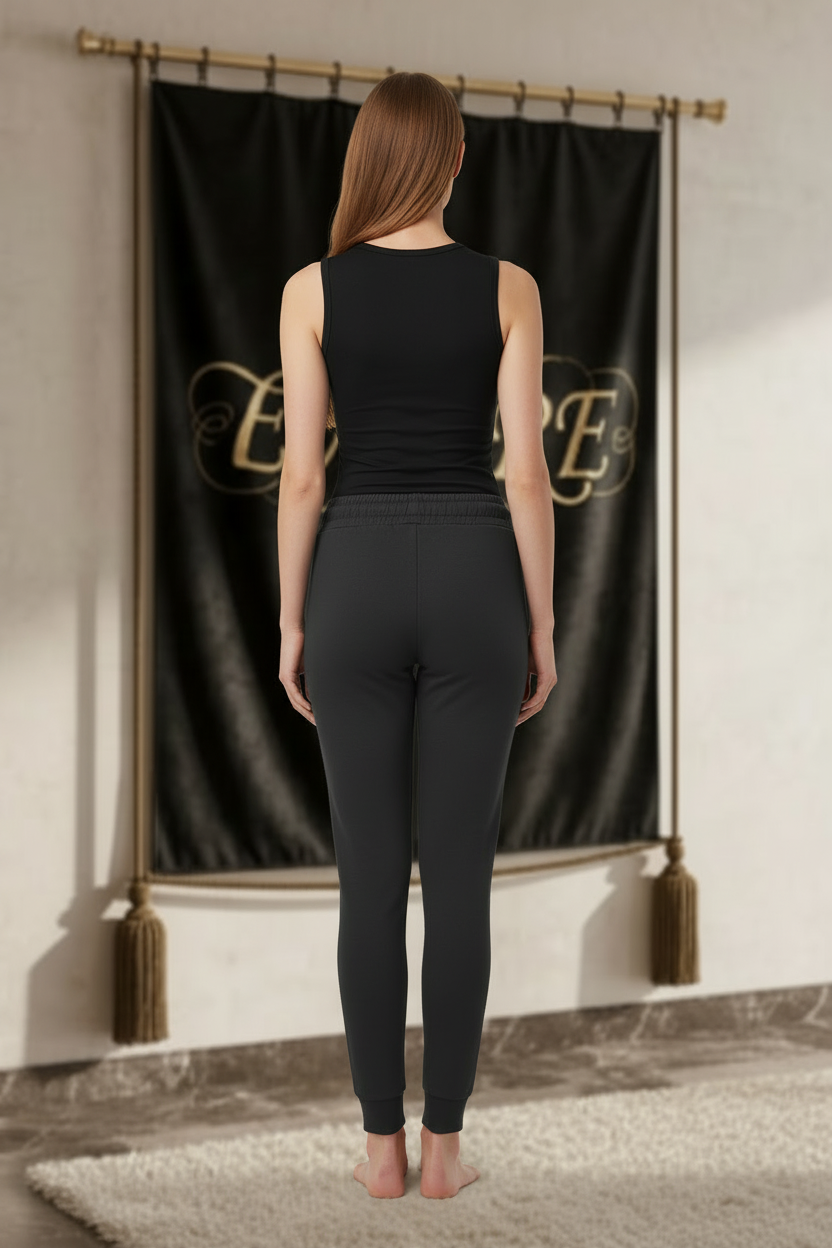 Femme portant le jogger EMPIRE noir ajusté, uni au dos avec chevilles côtelées, vue arrière.