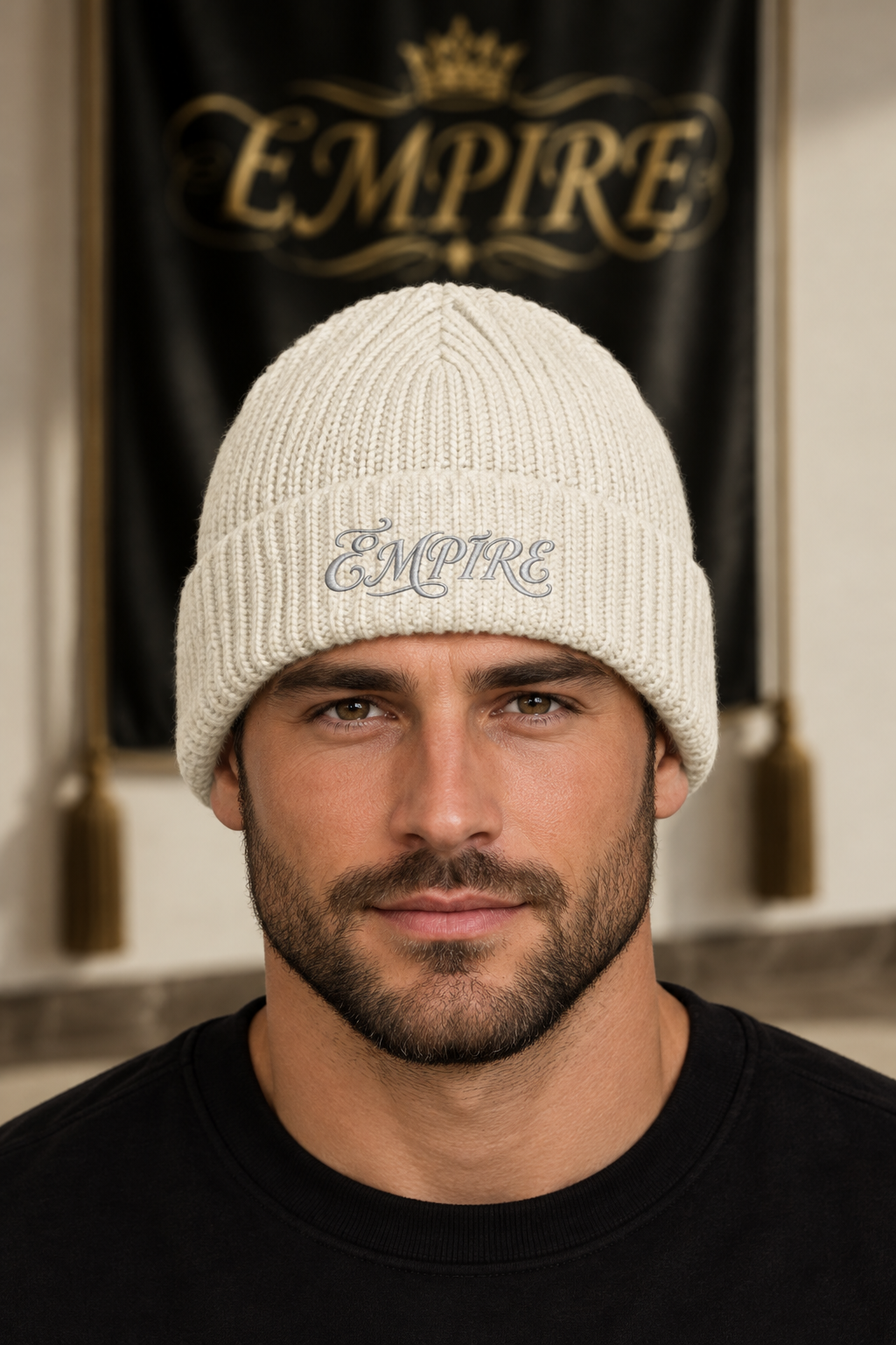 Bonnet côtelé écru homme EMPIRE Gauge, broderie fine grise sur le revers, porté en gros plan dans le décor EMPIRE