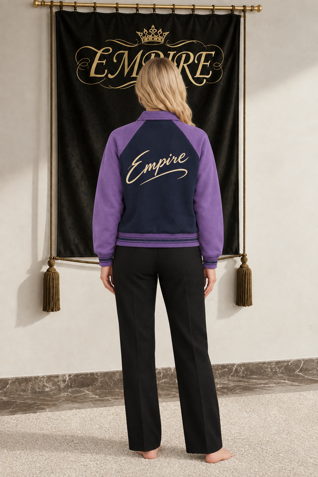 Veste baseball femme EMPIRE bleu nuit à manches violettes, grande signature Empire champagne avec trait souple au dos, vue arrière sur mannequin
