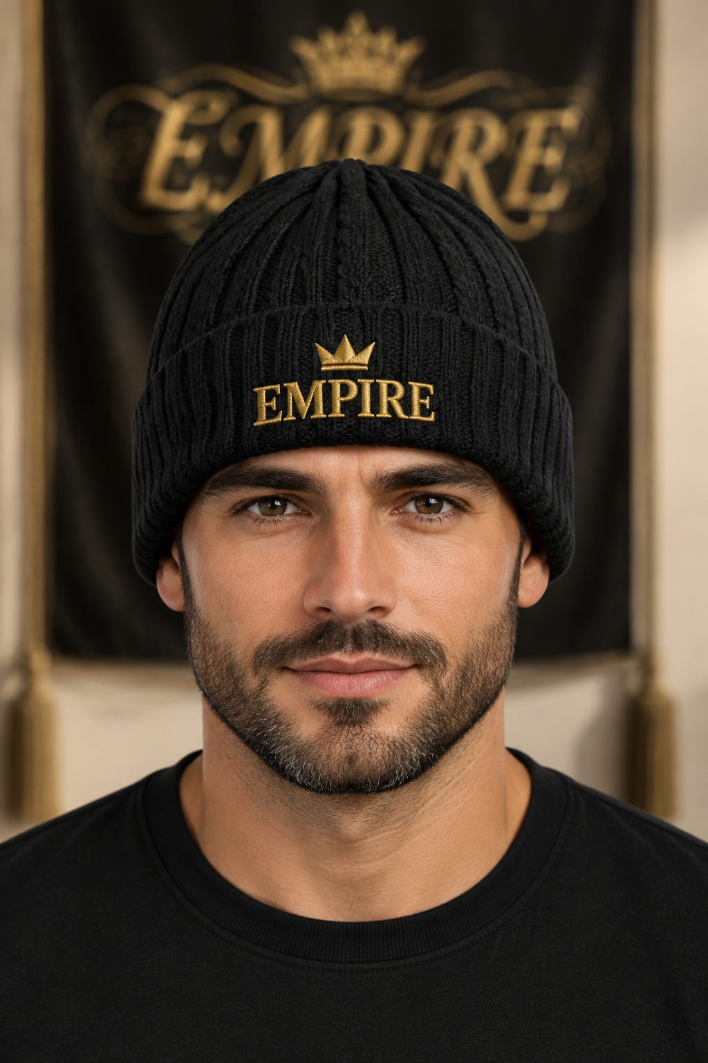 Bonnet noir en maille torsadée homme EMPIRE, couronne et inscription EMPIRE brodées dorées sur le revers, porté en gros plan dans le décor EMPIRE