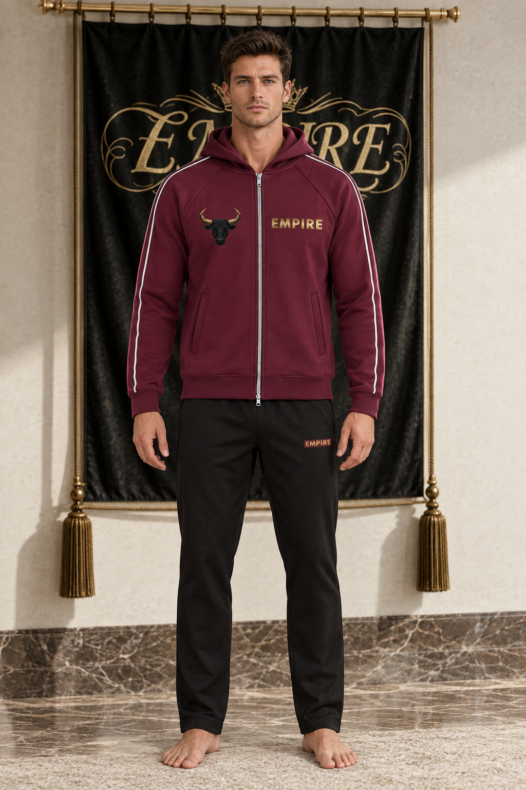 Burgundy men's EMPIRE raglan-sleeve zip hoodie with black bull chest emblem and gold wordmark, front view on barefoot male model