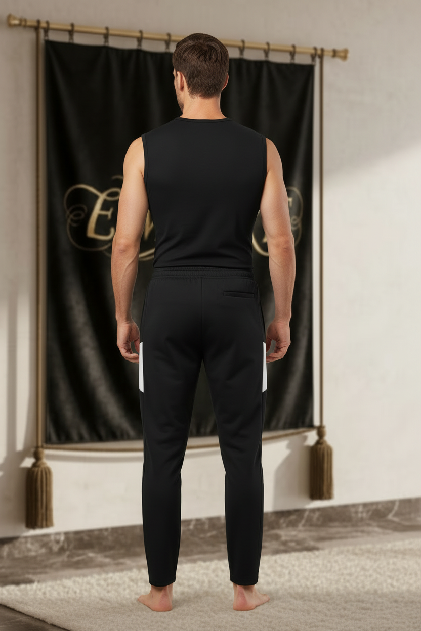 Homme portant un pantalon EMPIRE Performance Travel Pants noir avec deux panneaux blancs sur le haut des côtés, sans logo au dos, vue arrière.