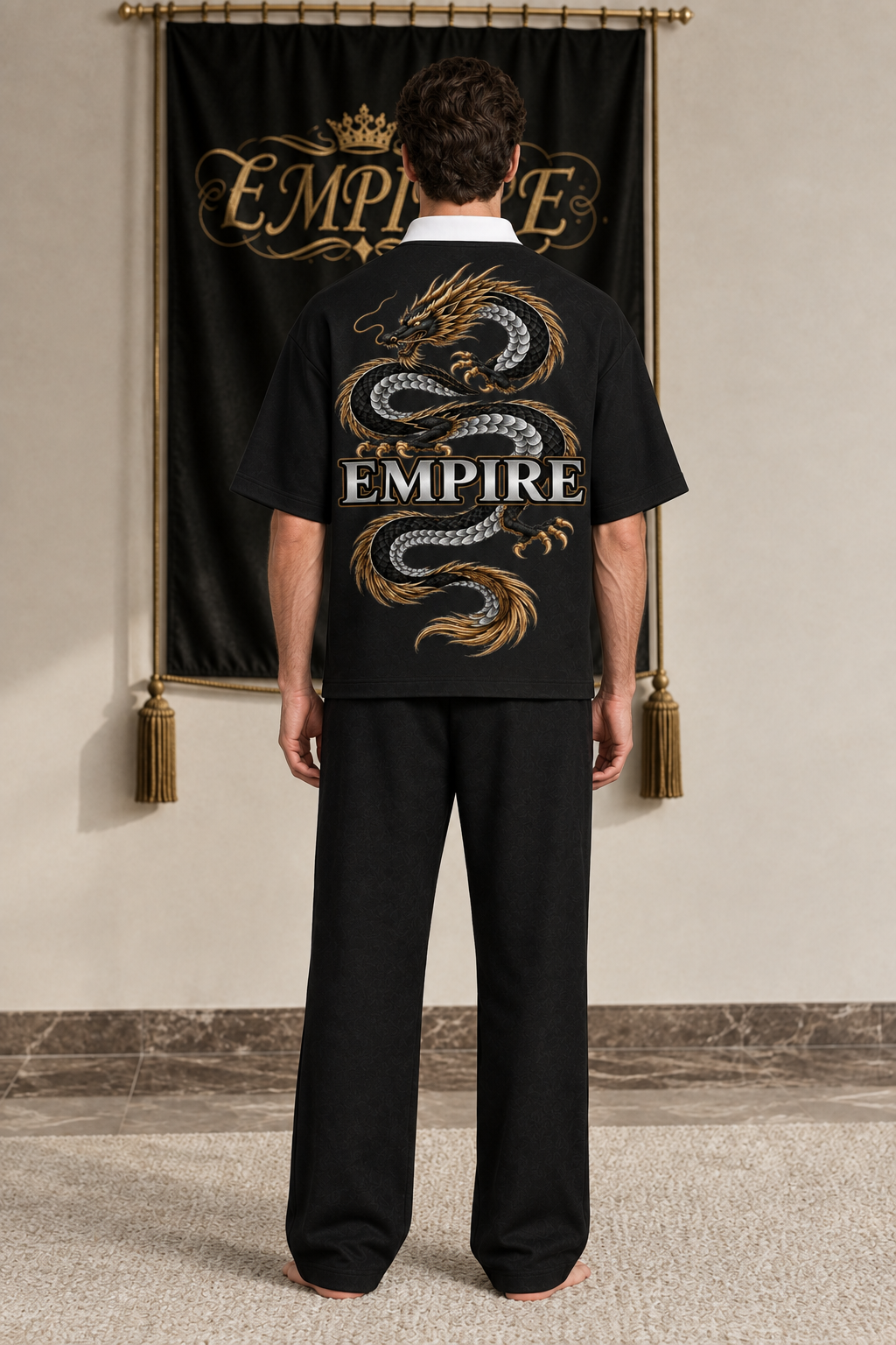 Black men's EMPIRE contrast-collar polo shirt with large silver-and-gold dragon and central wordmark, rear view on barefoot male model