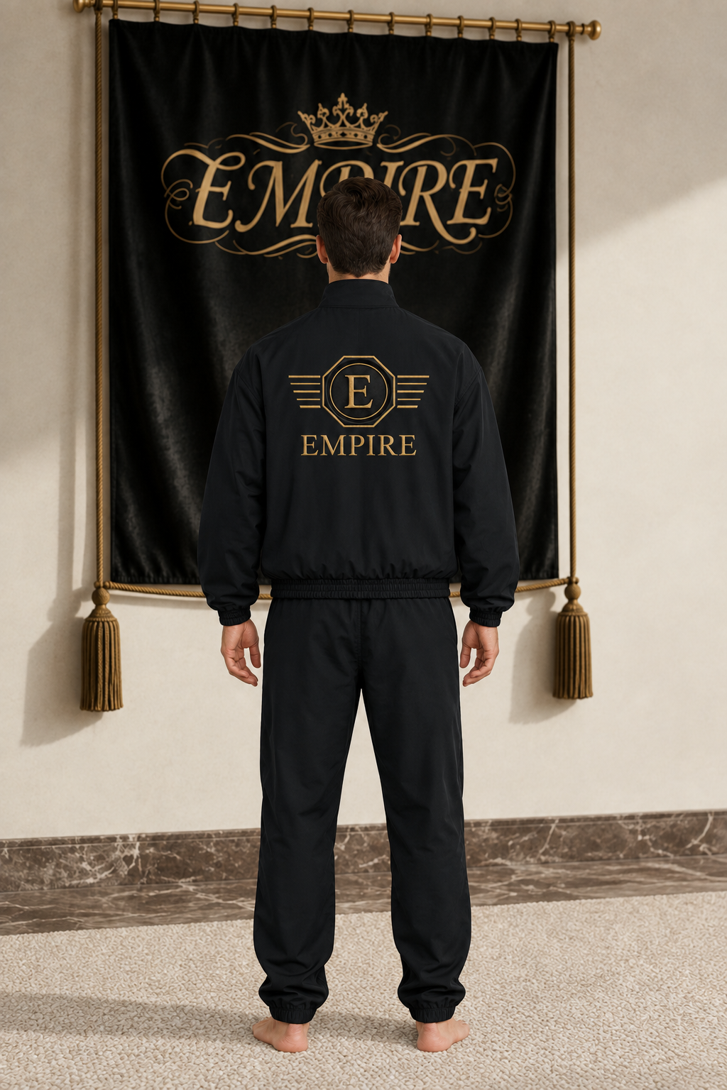 Black men's EMPIRE loose stand-collar bomber jacket with large gold Empire Signet back artwork, rear view on barefoot male model