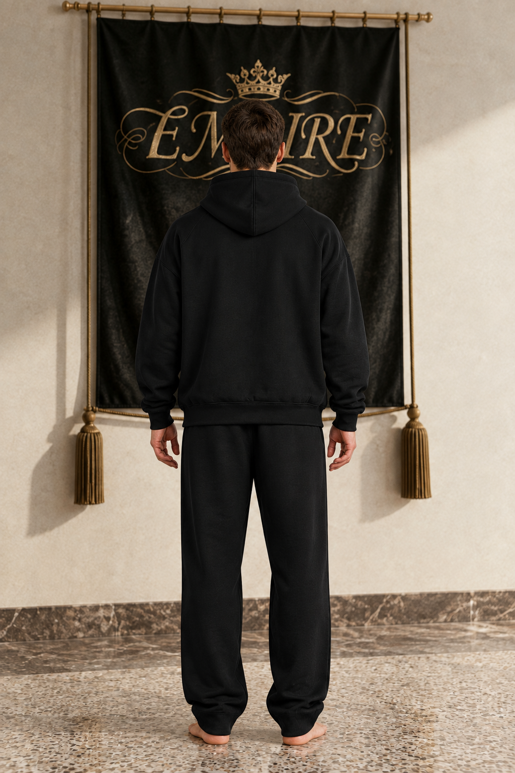 Black men's EMPIRE oversized drop-shoulder hoodie with plain back, rear view on barefoot male model