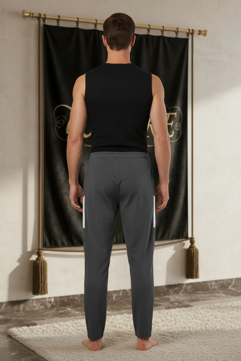 Homme portant le pantalon EMPIRE Performance Travel Pants gris anthracite fuselé avec panneaux blancs latéraux, sans logo au dos, vue arrière.