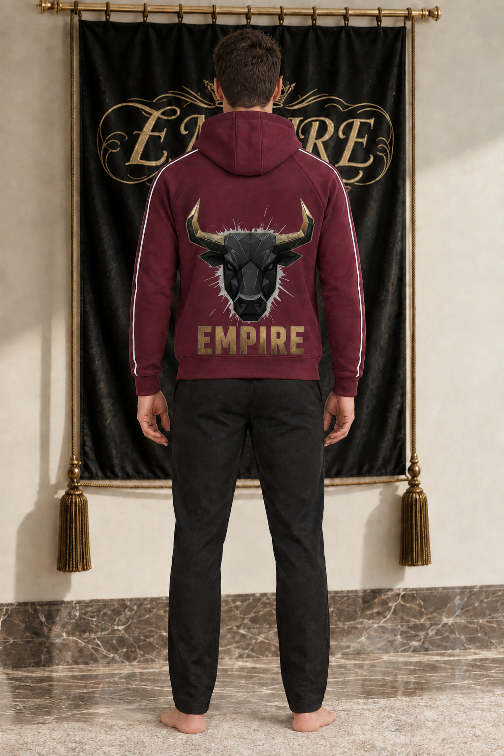 Burgundy men's EMPIRE raglan-sleeve zip hoodie with wide lower-positioned geometric black bull and gold wordmark, rear view on barefoot male model